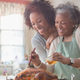 Two women embracing and preparing Thanksgiving turkey